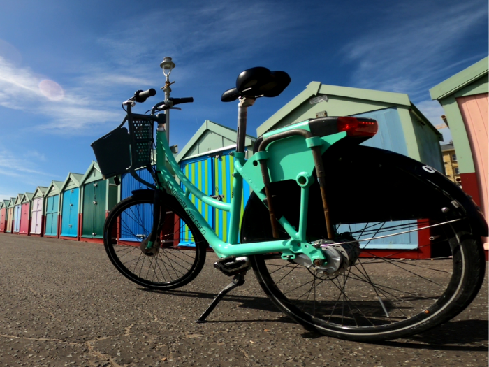 "A picture of a bike in front of some beach huts "