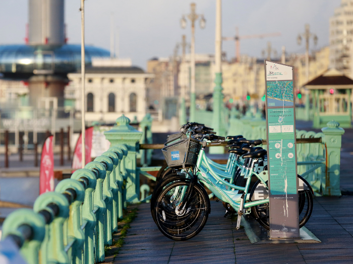 "a picture of a rack of bikes on a seafront promenade"