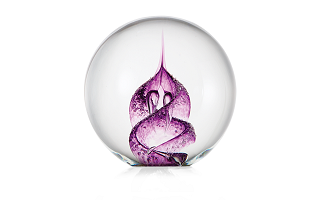 "glass paperweight with purple swirled pattern in the middle"