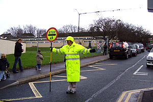 A School Crossing Patrol stopping traffic in the road