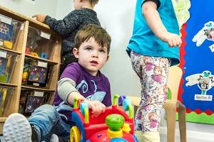 A boy plays with toys on the floor