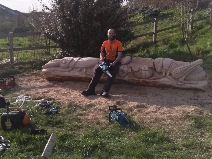 Daniel Cordell sits on his carved bench