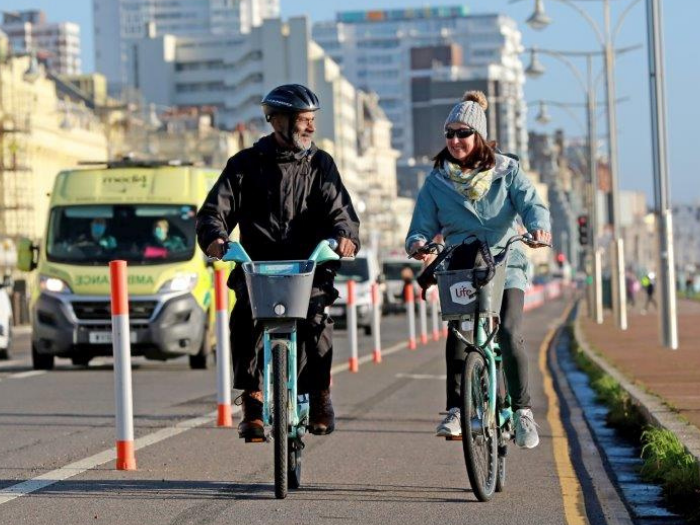 "Two people cycling along a temporary cycle lane in Brighton"