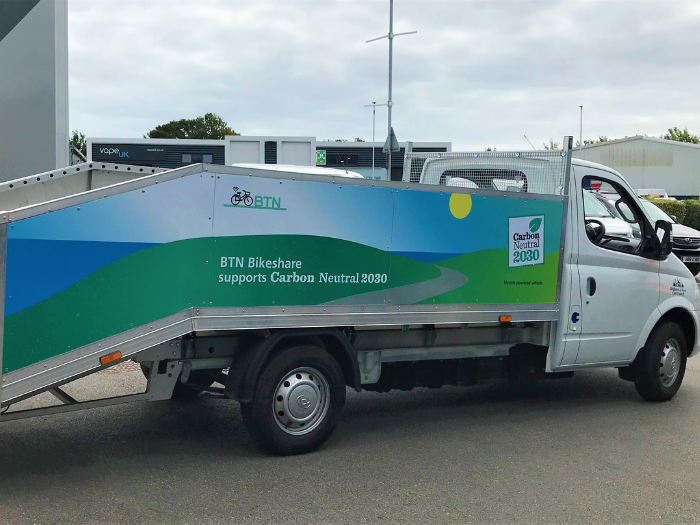 "A van with paneling on the side reading 'BTN BikeShare supports Carbon Neutral 2030"