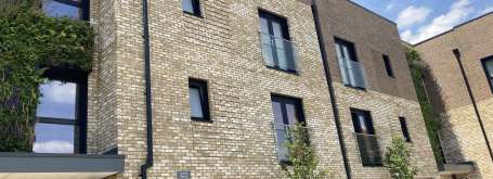 Image of outside of apartment block with light brick.