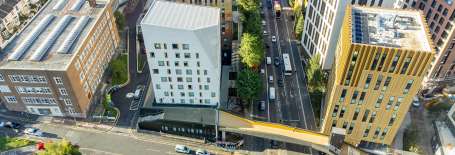 Image of tall buildings and road with cars on from above.