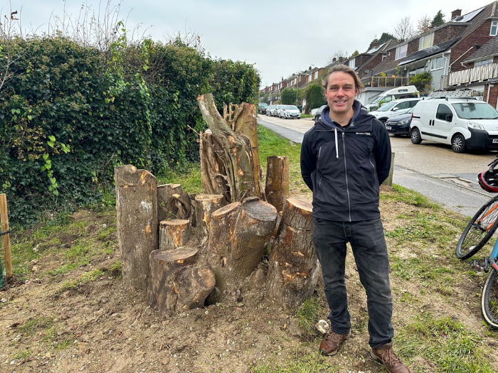 A man standing next to some logs