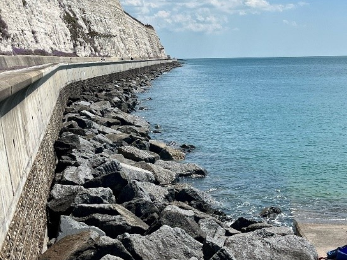 An image of the sea and a rock wall