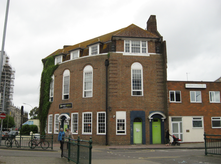 Image of The Former Richmond Hotel, Richmond Place, Brighton. A large red brick building with green doors.