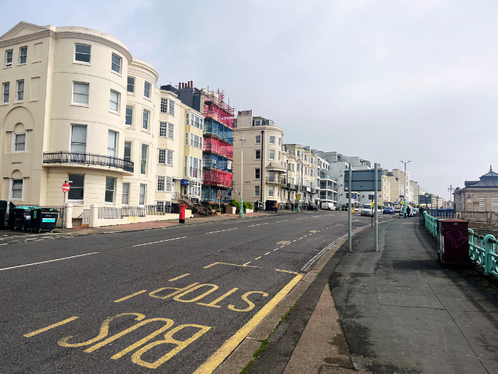 A picture of a road, bus lane and buildings