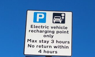 Time limited parking bay sign. Electric vehicle charging point online. Maz stay 3 hours. No return within 4 hours.