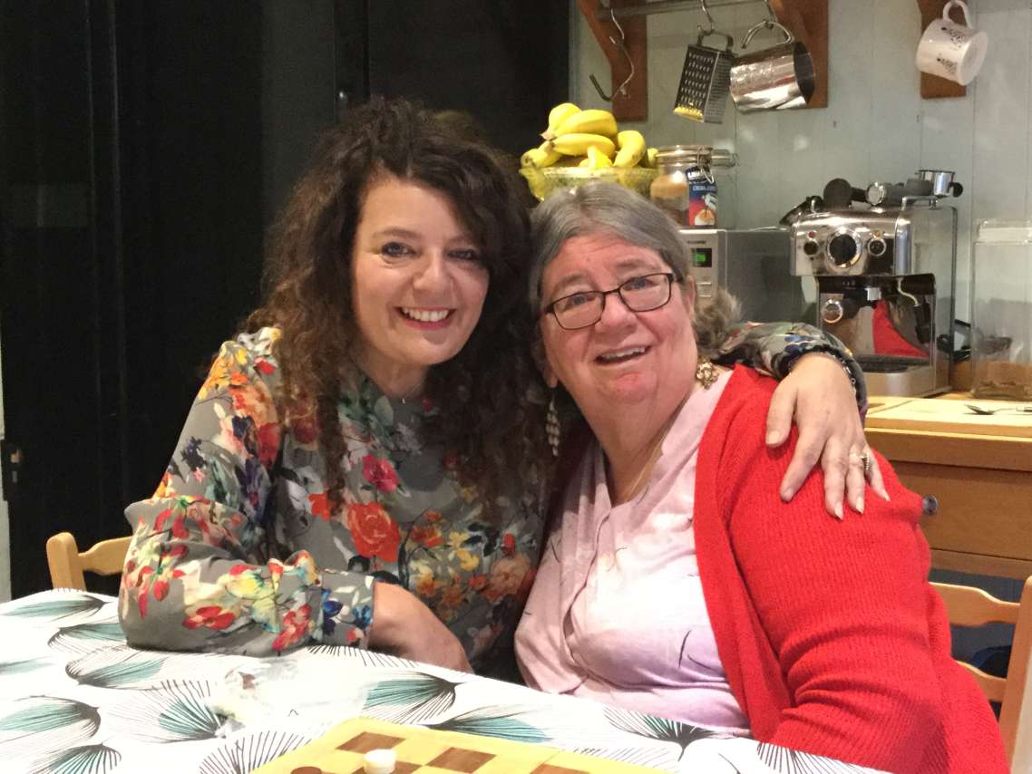 A photo of 2 people sitting at a kitchen table
