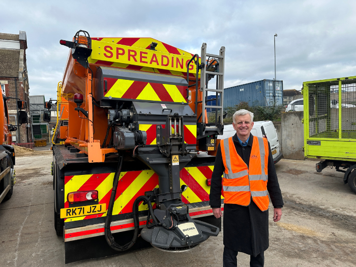 A man standing in front of a gritting lorry