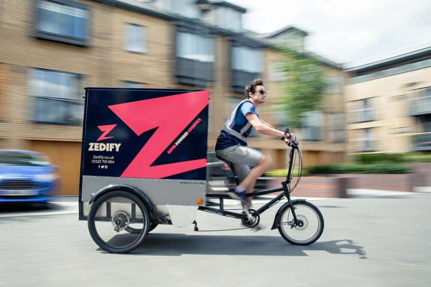 Person riding an e-cargo bike in the city.