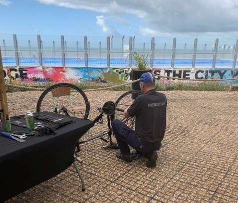 Man crouching on the ground looking at upside down bike.