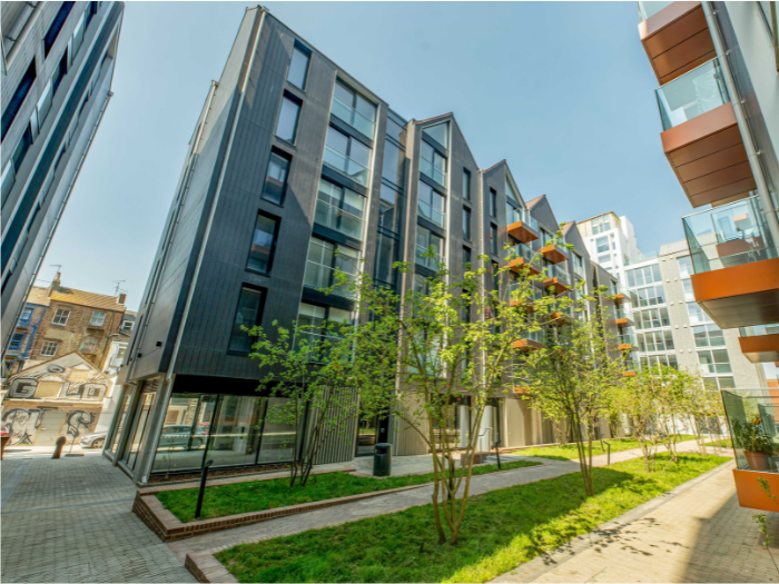 a view across a newly planted green space to a Circus Street residential block