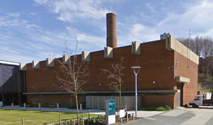 The west frontage of the Boiler House with brick chimney behind.