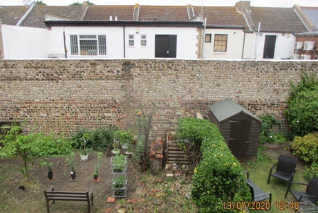 The tall flint wall taken from rear gardens.