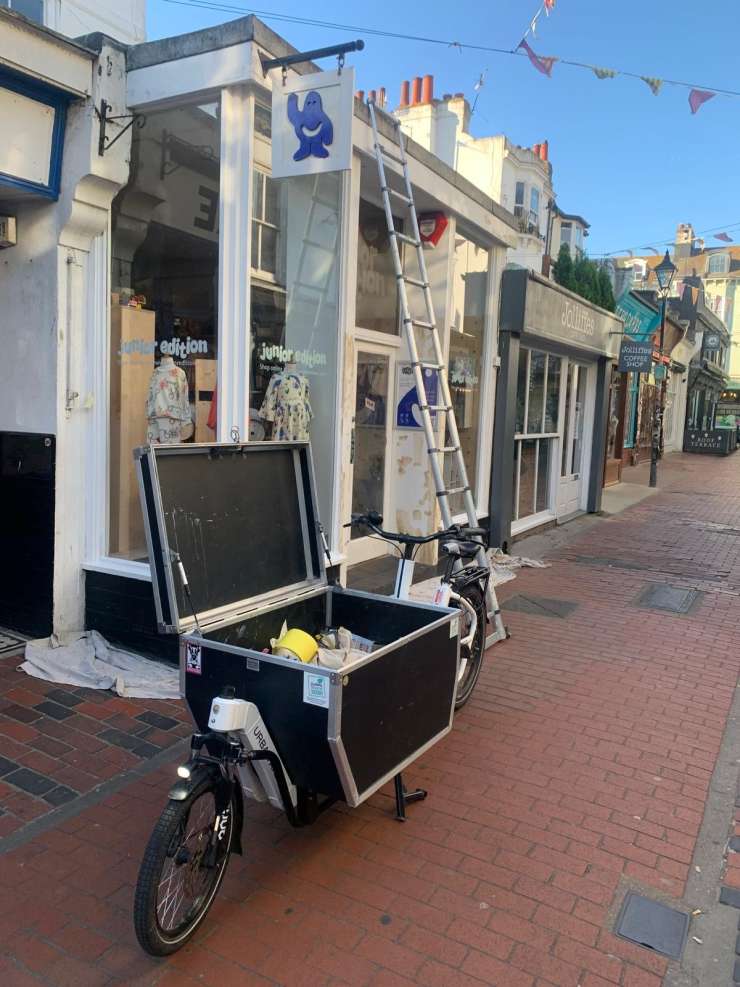 An eCargo bike outside a shopfront which is being decorated.