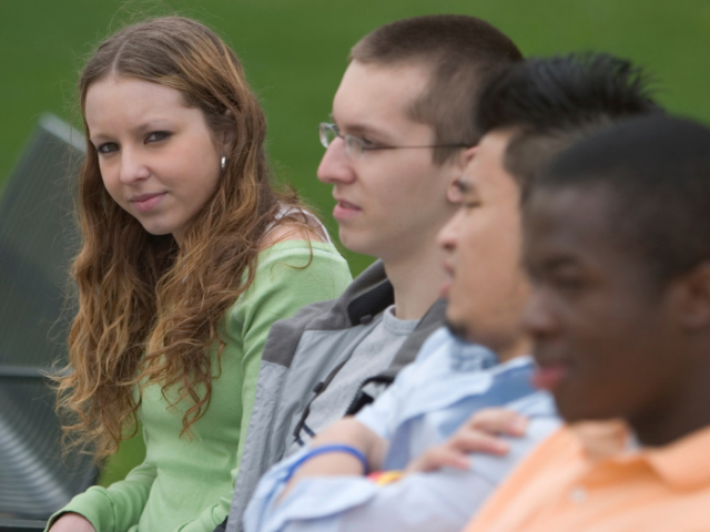 Four teenagers sat on a bench