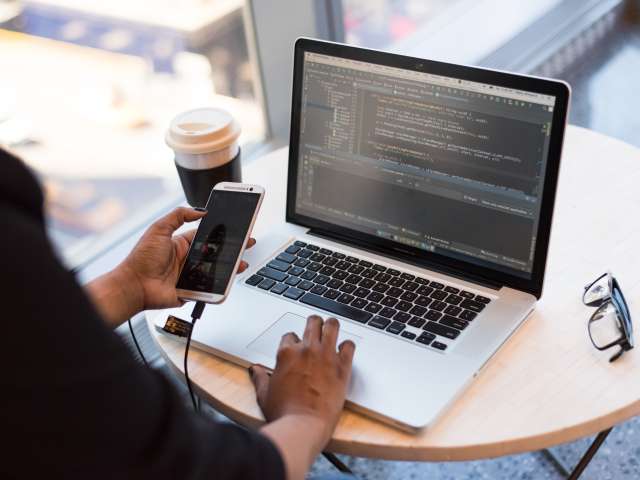 Business person sitting in front of a laptop applying for a business grant