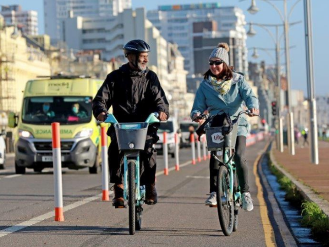 Two people cycling on a temporary cycle lane in Brighton