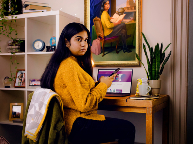 Young woman sitting at a desk with the census 2021 website open on a laptop
