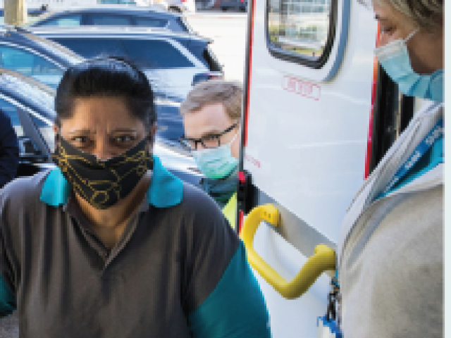 Woman entering mobile vaccination service ambulance.