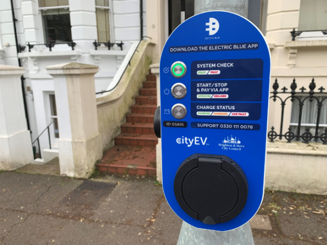 A picture of a blue electric vehicle charging point attached to a lamppost