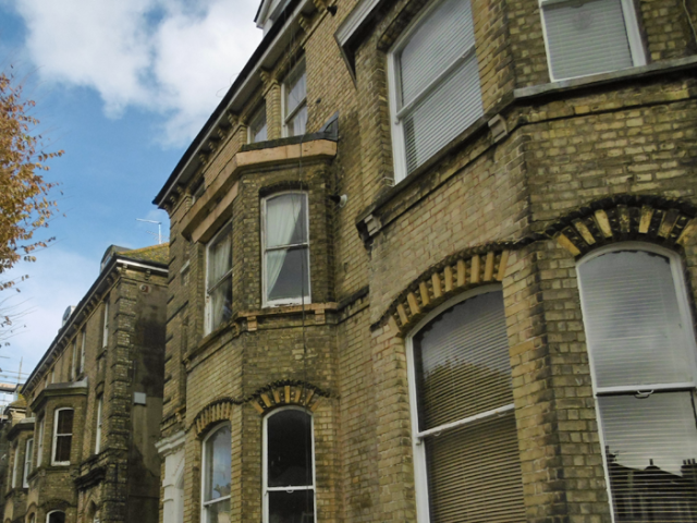 Photograph looking along the front of  a few large terraced houses in central Brighton & Hove