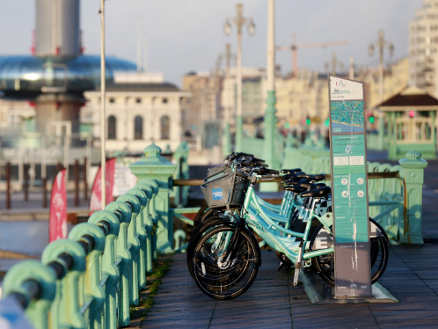 A picture of a rack of bikes on a seafront promenade