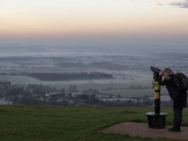 Person looking through a telescope over Devil's Dyke