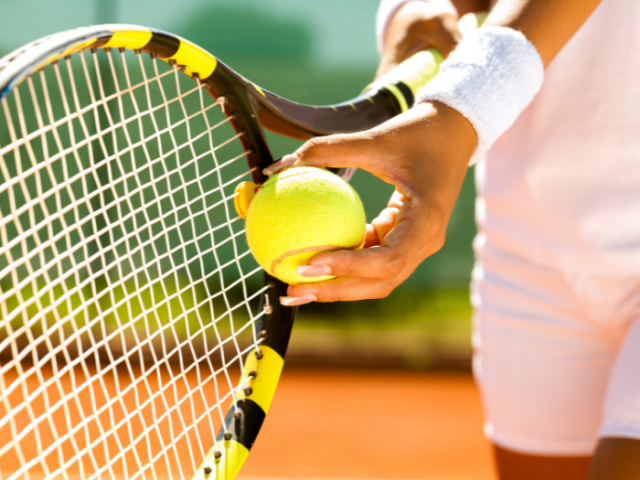 person holding a tennis ball and racket