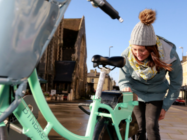 A woman using a keypad on a bicycle