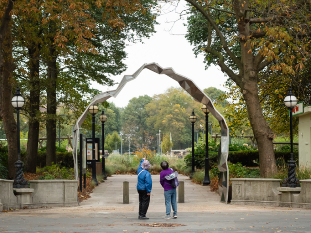 Photo of two people standing under the Happenstance archway at The Level entrance