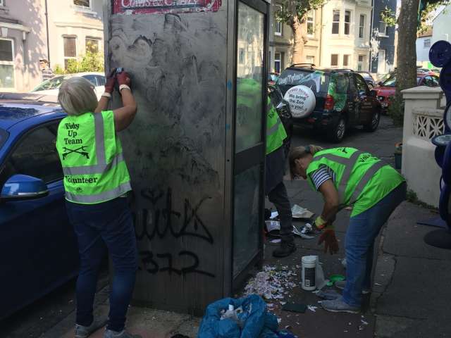 Tidy Up Team Collecting Litter and de-stickering a phone box