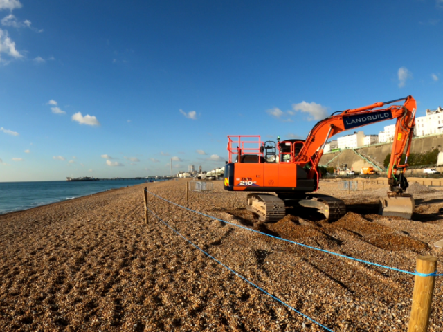 A picture of a bulldozer picking up shingle on a beach