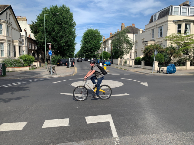 A cyclist crossing a roundabout
