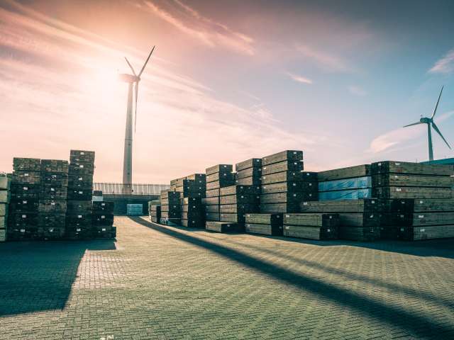 Wind turbines and piles of containers at Shoreham Port against sunset sky