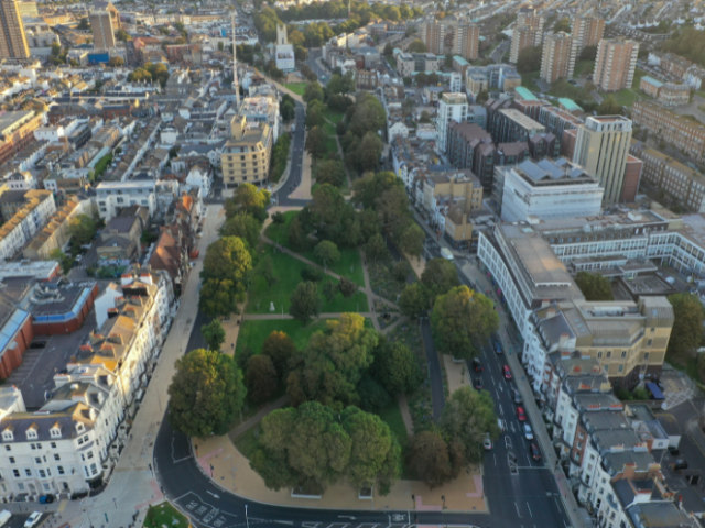 An aerial view of Valley Gardens showing the tress and large green space of the gardens with the new road system and buildings on either side