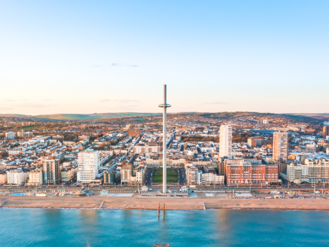 View of Brighton seafront from the sea. Featuring the i360 and views of the city and South Downs in the distance.