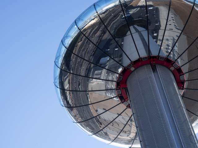 A photo of the i360 viewing pod taken from below, the sunlight is reflecting off of the chrome base