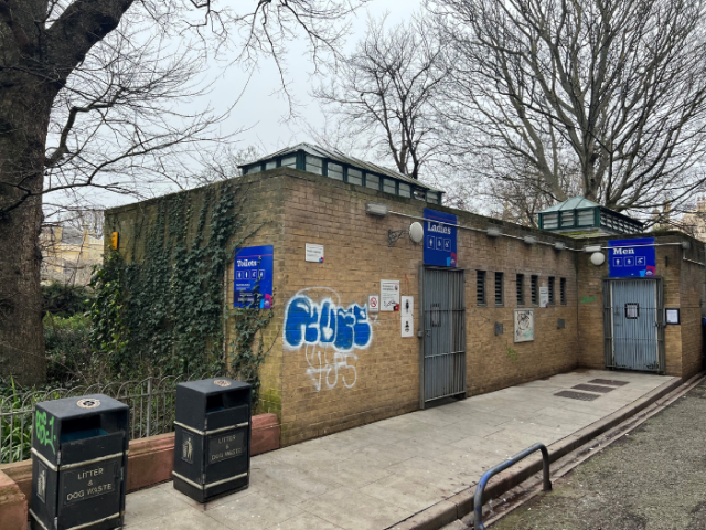 The photograph shows a brick built toilet block with the doors locked shut.