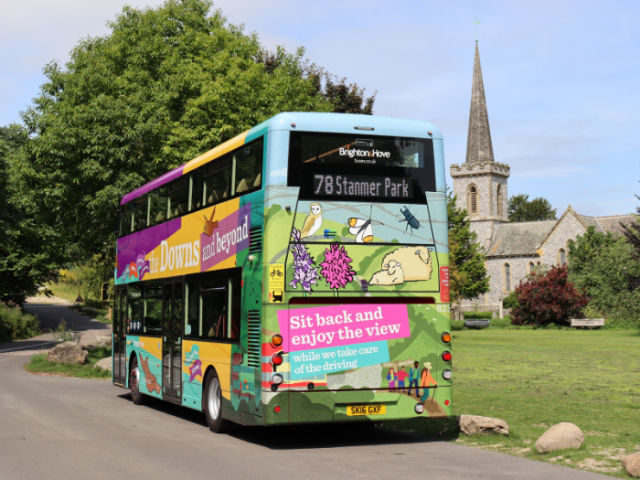 A colourful bus with a church in the background