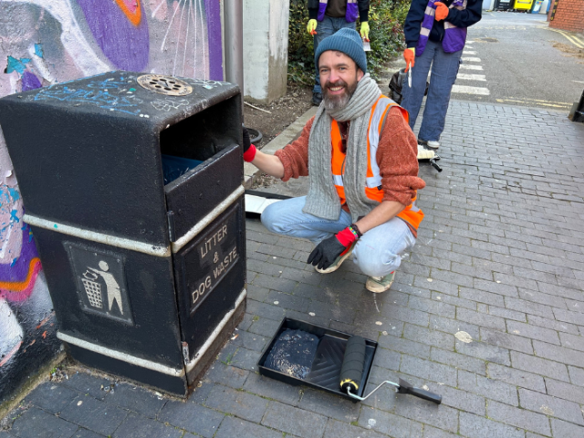 Photograph of councillor Tim Rowkins painting a bin in Brighton & Hove.