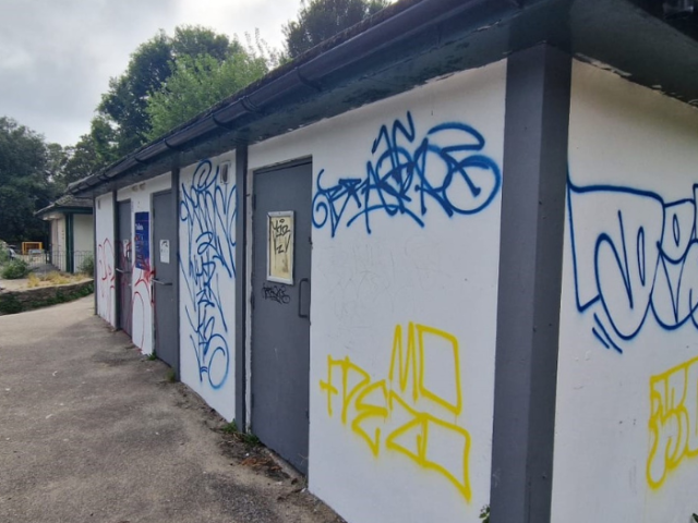 Photograph of graffiti tagged public toilet building.