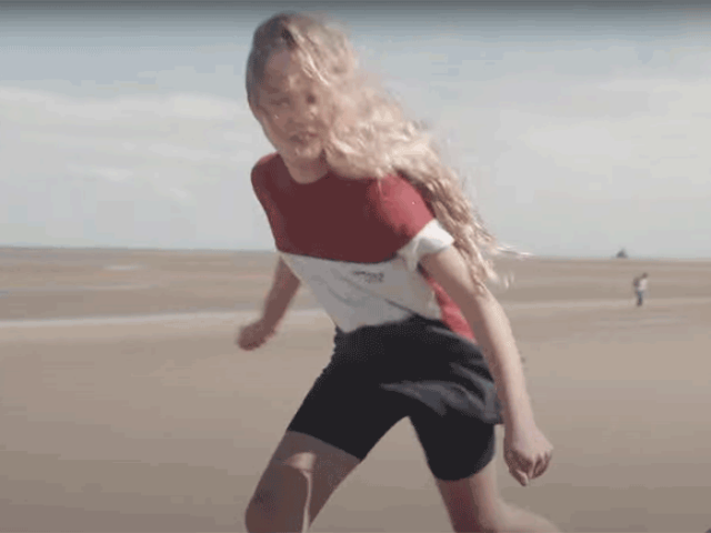 Still from the 'Any of us' fostering film showing a young girl running around on a sandy beach