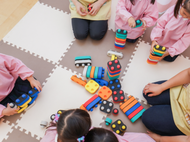 A group of children sitting on the floor playing with toys