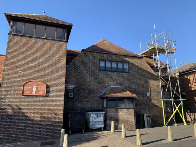 An outside view of the community centre, with scaffolding as repars to the roof get underway