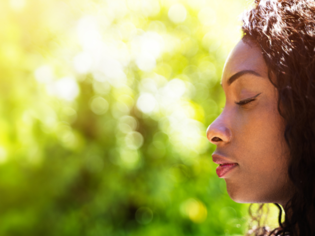 Woman with closed eyes and green background.